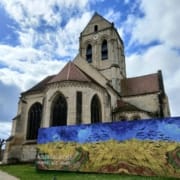 Kościół Notre-Dame-de-l'Assomption w Auvers-sur-Oise z reprodukcją obrazu Van Gogha Pole pszenicy z krukami