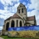 Kościół Notre-Dame-de-l'Assomption w Auvers-sur-Oise z reprodukcją obrazu Van Gogha Pole pszenicy z krukami
